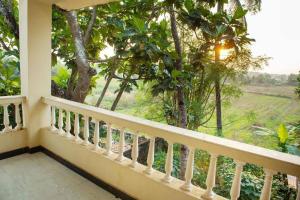 a balcony with a view of a field and trees at 2BHK Modern Suites in North Goa in Saligao