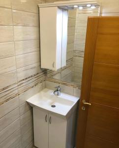 uma casa de banho com um lavatório branco e um espelho. em Apartman Agović em Bar
