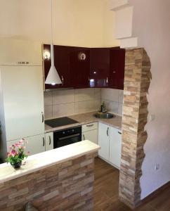 uma cozinha com armários brancos e uma bancada em Apartman Agović em Bar