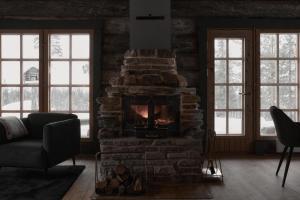 a living room with a stone fireplace and a couch at The Fell in Levi