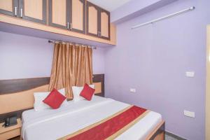 a bedroom with a bed with red pillows at Collection O Blossom Suites in Bangalore