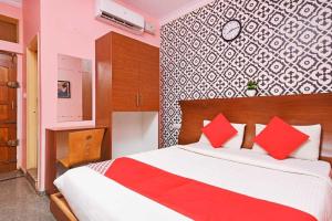 a bedroom with a large bed with red pillows at Collection O Blossom Suites in Bangalore
