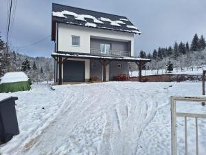 una casa en la nieve con huellas en la nieve en Holiday Home Mali Raj, en Pale