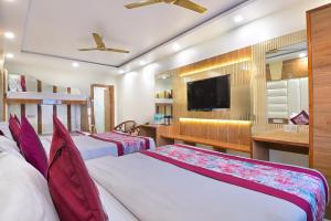 a bedroom with two beds and a flat screen tv at Hotel Glow Inn Paharganj-3 Mins Walk From New Delhi Railway Station in New Delhi