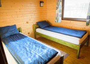 Habitación con 2 camas en una cabaña de madera en Country Garden - Országkert, en Păuleni-Ciuc
