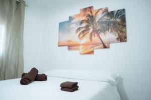 Un dormitorio con una cama blanca con palmeras. en City town apartment, en Santander