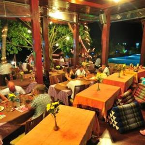 a group of people sitting at tables in a restaurant at Haad Yao Bayview Hotel in Ko Phangan