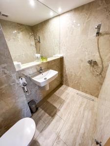 uma casa de banho com um lavatório e um chuveiro em Christina Hotel em Bucareste