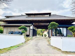 une maison avec une route devant elle dans l'établissement 一宿一景一生縁-千葉小湊鉄道高滝店, à Ichihara