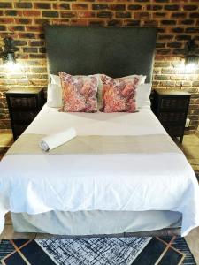 A bed or beds in a room at Kameelboom Lodge