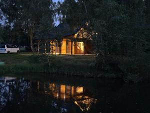 a house sitting next to a body of water at Sauna House Smyczyna in Smyczyna