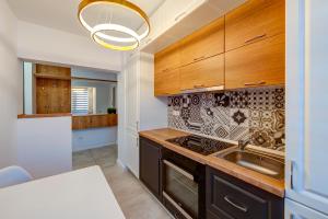 a kitchen with wooden cabinets and a sink at Montana Popa ApartHotel in Blaj