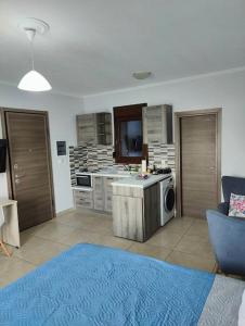a living room with a kitchen with a stove top oven at Varkaris Room 1 in Katarráktis