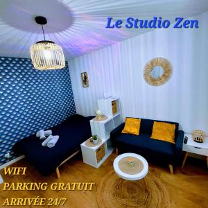 a living room with a couch and a table at Le Studio Zen "parking gratuit" in Cherbourg en Cotentin