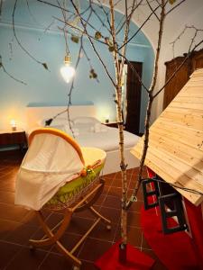uma cadeira sentada ao lado de uma árvore num quarto em WOW HOUSE in Torino em Turim