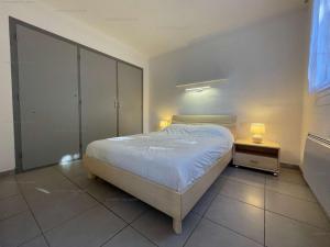 - une chambre avec un lit et 2 tables de nuit avec des lampes dans l'établissement 4VSE-VER4 - Très bel appartement idéalement situé avec parking privé, à Collioure