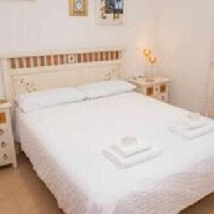 1 dormitorio con cama blanca y mesa en Preciosa casa adosada con piscina privada, en Mojácar