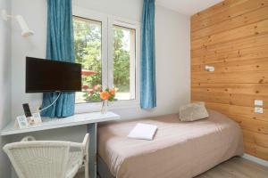 een slaapkamer met een bed, een bureau en een raam bij Hôtel Acacia Nancy sud Lunéville in Lunéville