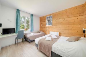 ein Hotelzimmer mit 2 Betten und einem TV in der Unterkunft Hôtel Acacia Nancy sud Lunéville in Lunéville