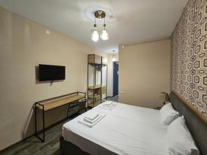 Habitación de hotel con cama y TV de pantalla plana. en Casa Del Mar en Kvariati