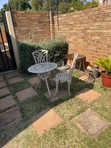 duas cadeiras e uma mesa e uma mesa e cadeiras num quintal em 642 on Vincent em Pretoria