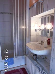 a white bathroom with a sink and a mirror at Gästehaus Auhagen in Auhagen