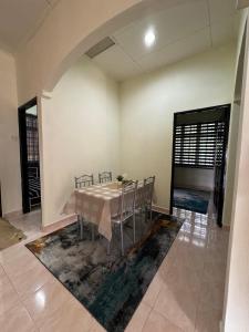 a dining room with a table and chairs in a room at Syurgaku Homestay Tanah Merah in Tanah Merah