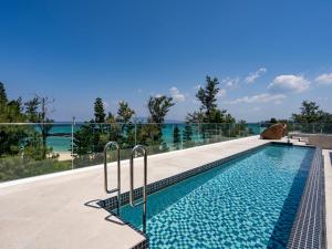 a swimming pool on the roof of a house at UMITO PLAGE The Atta Okinawa in Onna