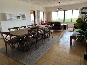 a dining room with a wooden table and chairs at Lighthouse Villa in Cape St Francis