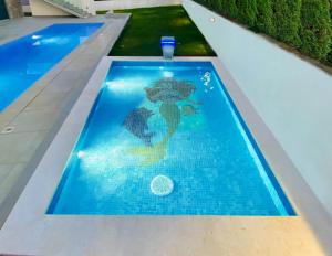 - une piscine avec une sirène peinte au sol dans l'établissement 5 Sterne Villa am Meer mit 2 Pools Leon'sHolidayHomes, à Pula