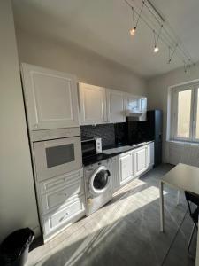 ストラスブールにあるle couventのキッチン(白いキャビネット、洗濯機、乾燥機付)