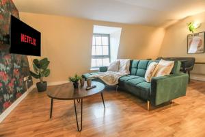 a living room with a green couch and a table at Luxurious 1 Bed Apartment with Free Parking in Nottingham