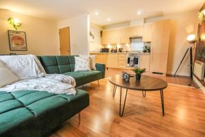 a living room with a green couch and a table at Luxurious 1 Bed Apartment with Free Parking in Nottingham