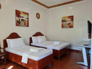 a room with two beds and a desk in it at Alona Hidden Dream Resort by SMS Hospitality in Panglao +18 photos