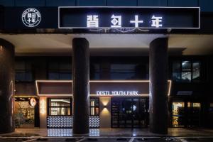 a sign in front of a building at night at Changsha Desti Youth Park Hostel in Changsha