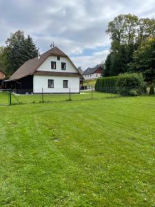 um grande campo de relva com uma casa branca em Chata Kunvald em Kunvald