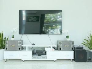 una sala de estar con TV en un centro de entretenimiento blanco en Private Home in District 7, en Ho Chi Minh