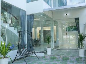 un salón acristalado con paredes de cristal y macetas en Private Home in District 7, en Ho Chi Minh