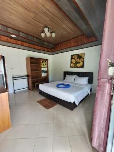 Un dormitorio con una cama y un techo de madera. en Lanta Mermaid Resort, en Ban Ai Dao