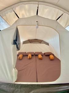 a white tent with three pillows in it at SoraCai Riverside Campsite in Palayangan