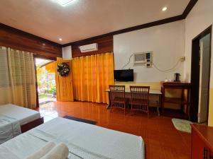 a bedroom with a bed and a table with chairs at Alona Hidden Dream Resort by SMS Hospitality in Panglao