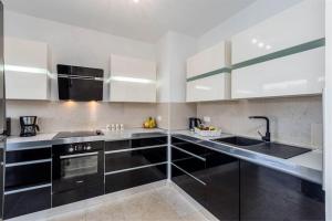 a kitchen with black and white cabinets and a sink at Villa Liv by Istrialux in Hreljići