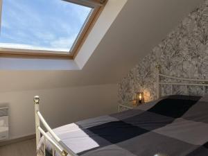 Schlafzimmer mit einem Bett und einem großen Fenster in der Unterkunft 207 - Jolie maison mitoyenne entre terre et mer en campagne de Plurien in Plurien