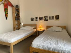 a bedroom with two beds and a book shelf at 359 - Appartement T3, à deux pas de la plage l'Anse du Croc et de sa vue sur le Cap Fréhel in Fréhel