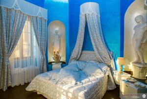 a blue bedroom with a bed with blue walls and curtains at Palazzo Moraschi Subiaco in Subiaco