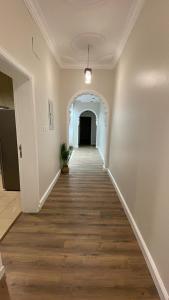 an empty hallway with a long wooden floor in a house at شقة بموقع مميز قريبة من الحرم في قلب المدينة وبجانبها جميع الخدمات in Al Madinah