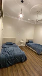 a bedroom with two beds and a table in it at شقة بموقع مميز قريبة من الحرم في قلب المدينة وبجانبها جميع الخدمات in Al Madinah