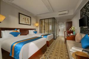 會安的住宿－Royal Riverside Hoi An Hotel & Spa，酒店客房,设有两张床和一张沙发