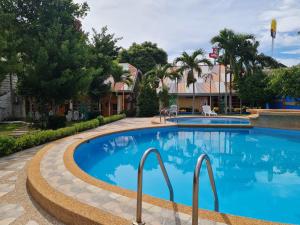 a swimming pool in a resort with trees and buildings at Alona Hidden Dream Resort by SMS Hospitality in Panglao
