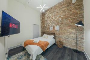 a bedroom with a bed and a brick wall at McCormick 6Br-4Ba Luxury Suite that sleeps 12 guests with Jacuzzi & Pool table, Group stay and Optional parking in Chicago